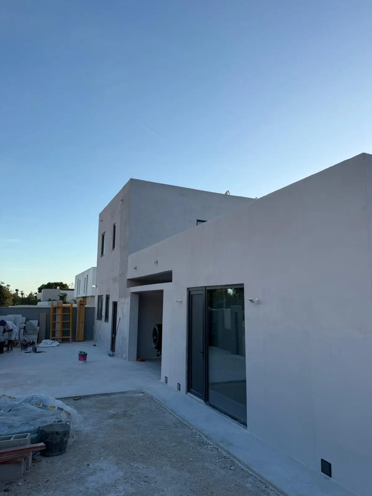 Trabajos de pintura en fachada de vivienda unifamiliar con acabado gris claro en Alicante