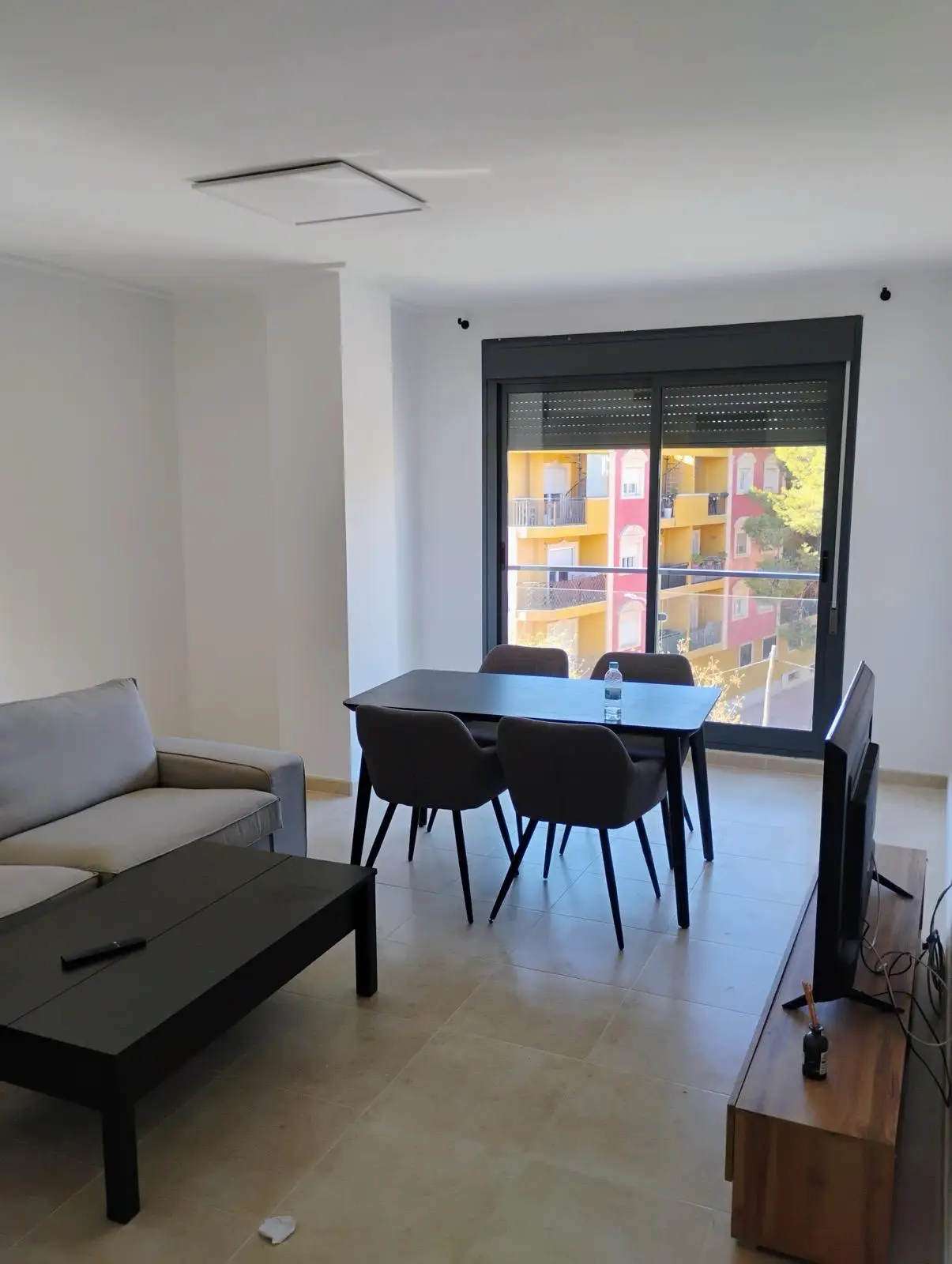 Servicio de pintura en salón con paredes blancas lisas y carpintería metálica oscura en Alicante