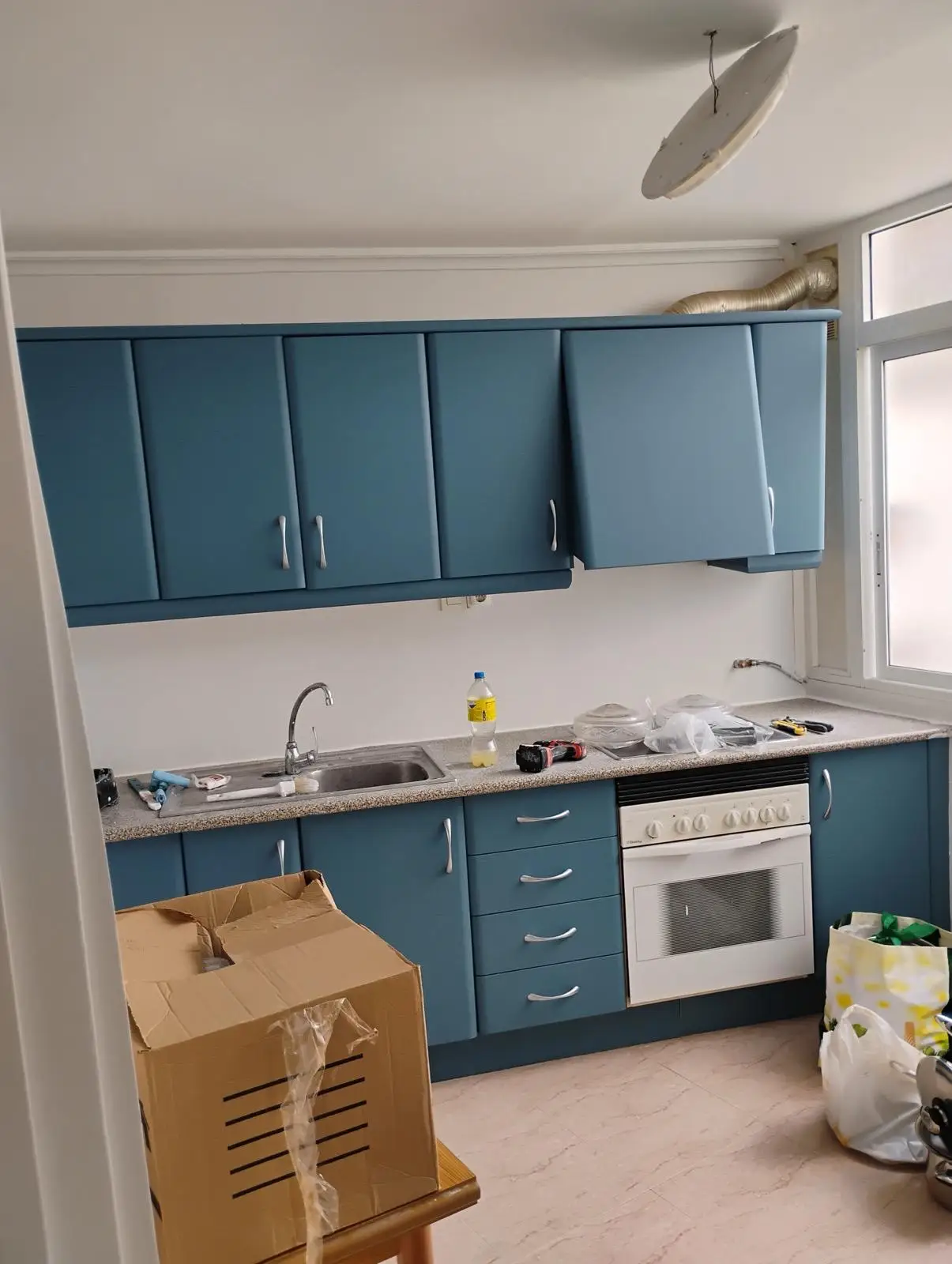 Reforma cocina con mobiliario azul mate, encimera de granito y fregadero de acero en Alicante